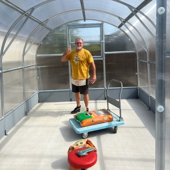 Polygrow polycarbonate greenhouse installed in a garden