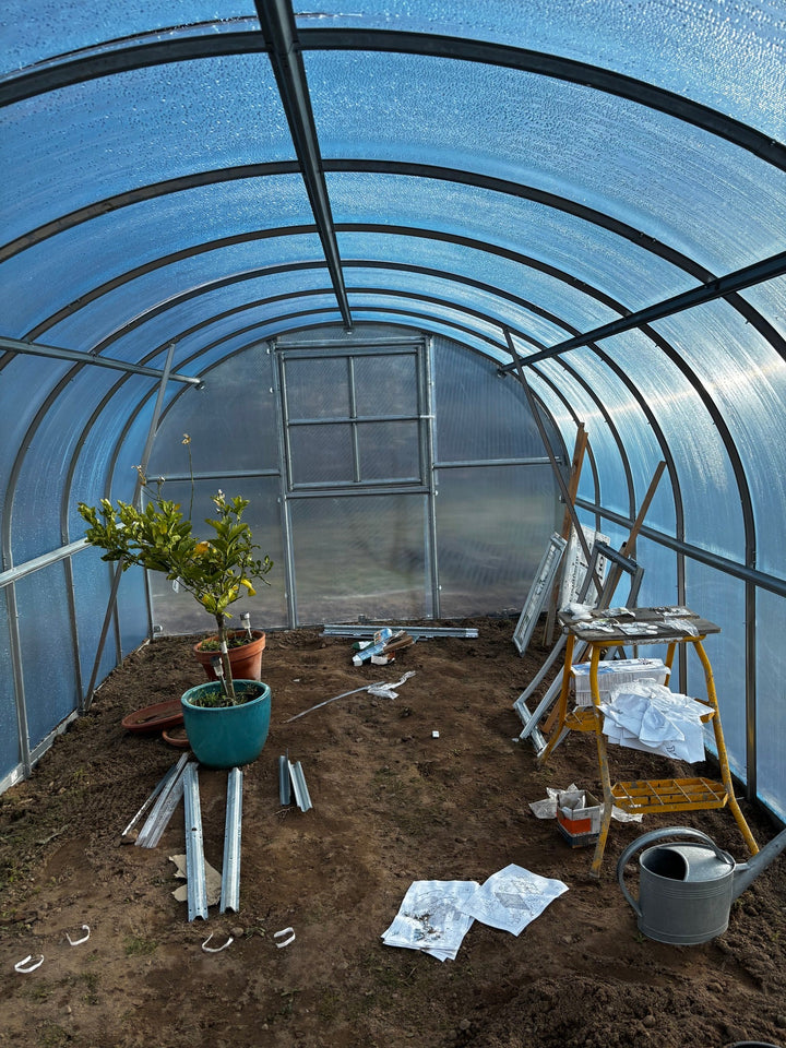Polygrow polycarbonate greenhouse installed in a garden