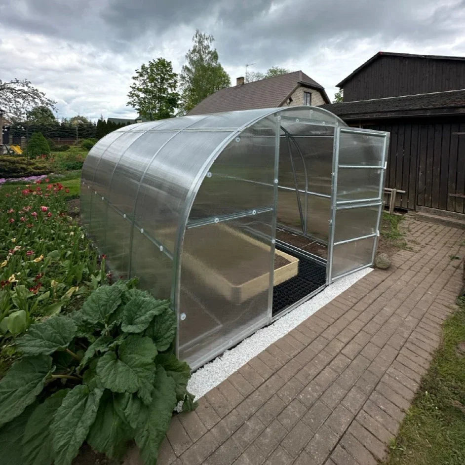 Polygrow polycarbonate greenhouse installed in a garden